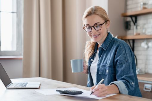 Woman taking notes while working at her desk